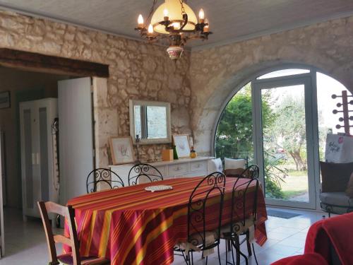 a dining room with a table and chairs and an archway at Chambres d'Hôtes Saint Roch in Tournecoupe