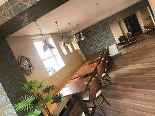 a restaurant with a long wooden table and chairs at Pavilion Holiday Apartments in Weston-super-Mare