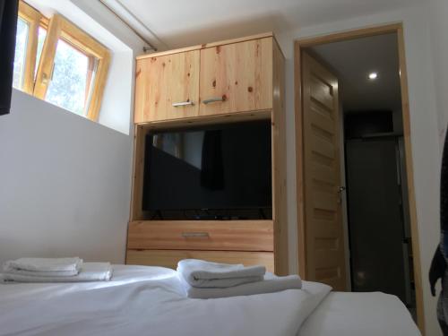 a bedroom with two beds and a tv and a cabinet at Modern Apartman Deluxe in Alsóörs