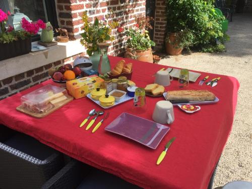 - une table de pique-nique avec de la nourriture sur un tissu de table rouge dans l'établissement La suite d'Arras, à Agny