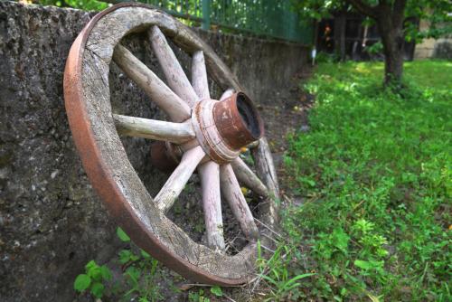 an old wagon wheel attached to a stone wall at Country house Dunjin Konak in Rogljevo
