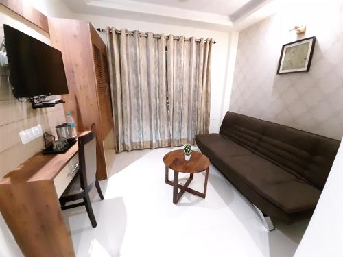a living room with a couch and a tv at Liza Regency in Chennai