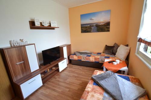 mały pokój z łóżkiem i kanapą w obiekcie Ferienhaus Hüfler 59 w mieście Kelbra