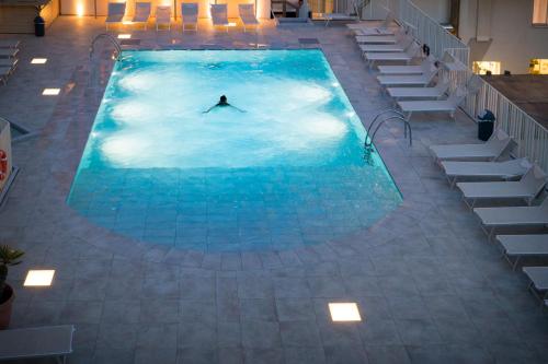 a person swimming in a large swimming pool at Hotel Villa Maria in Caorle