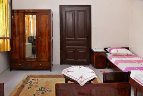 a bedroom with a door and a bed and a table at Country house Dunjin Konak in Rogljevo