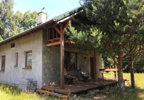 uma pequena casa com um alpendre e um deque em Leśny zakatek em Lubiatowo