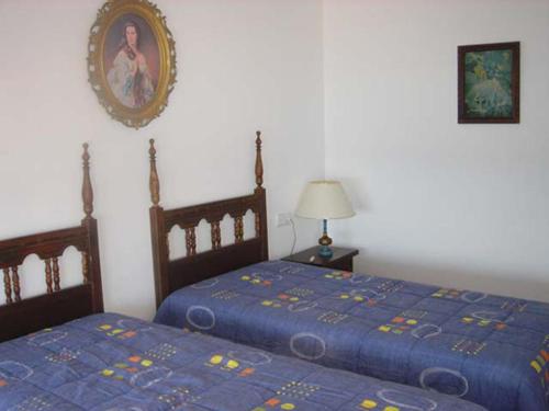a bedroom with two beds and a picture on the wall at Alexandra B-4 in Platja d'Aro