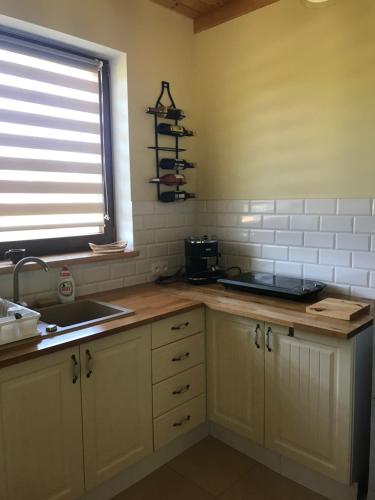 a kitchen with a counter and a sink and a window at Leśny zakatek in Lubiatowo