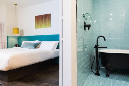 a bedroom with a bed and a bath tub next to a shower at The Russell in Nashville