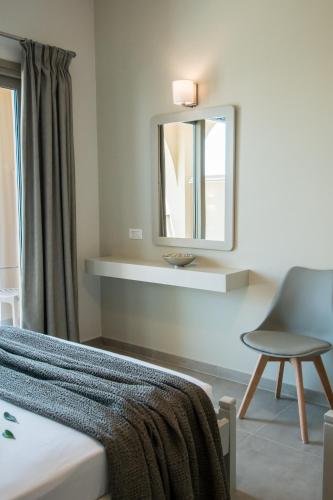 a bedroom with a mirror and a chair at Paradise Vezal in Laganas