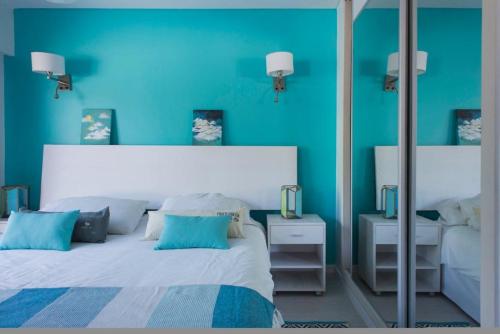 a blue bedroom with a bed and a mirror at Soho Point Central in Buenos Aires