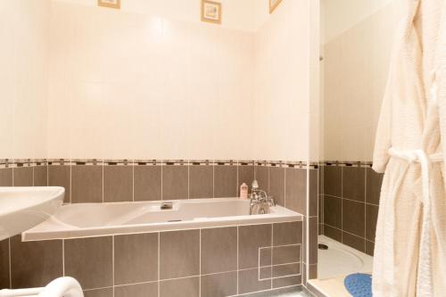 a bathroom with a tub and a sink at Chambres d'Hôtes Saint Roch in Tournecoupe