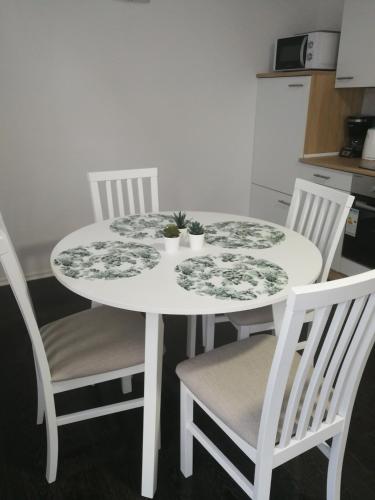 a white table with two chairs and two plants on it at New apartment near Plitvice lakes in Smoljanac