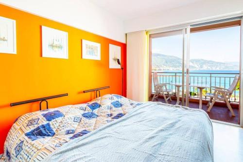 a bedroom with orange walls and a bed and a balcony at Terrazza Vista Mare, Parcheggio, Aria condizionata in Roquebrune-Cap-Martin