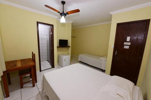 a bedroom with two beds and a ceiling fan at Hotel Castanheira in Ipatinga
