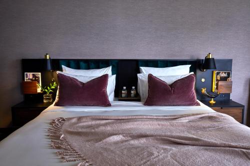 a bedroom with a large bed with red pillows at Fairlane Hotel Nashville in Nashville