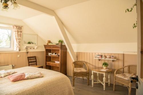 - une chambre avec un lit, une table et des chaises dans l'établissement boerderijkamer Zwanebloem, à Onstwedde