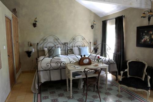 a bedroom with a bed and a table and a window at Justin de Provence in Orange