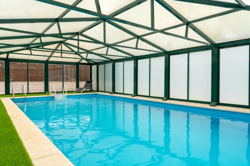 une piscine intérieure avec un toit en verre dans l'établissement El Mirador de la Atalaya, à Trescasas