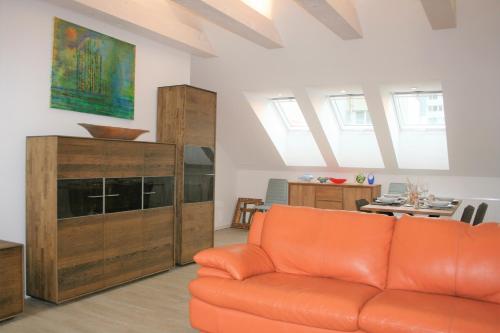 a living room with an orange couch and a cabinet at Bratislava design apartment in Bratislava