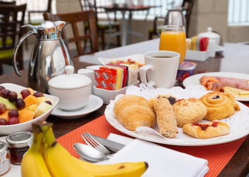 uma mesa com pratos de comida de café da manhã e bananas. em Radisson Aquatica Resort Barbados em Bridgetown