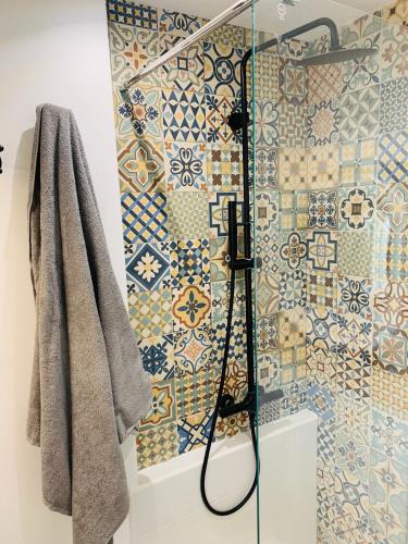 La salle de bains est pourvue d'une douche avec du carrelage en mosaïque. dans l'établissement Studio 24h 24h Parking Terrasse Internet, à Toulouse