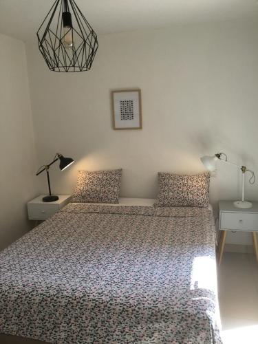 - une chambre dotée d'un lit avec deux lampes et un couvre-lit dans l'établissement Pins Parasol, à Fréjus