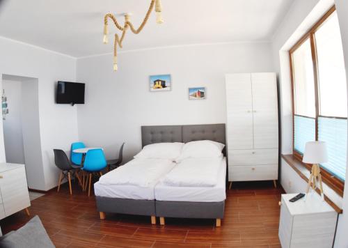1 dormitorio con 1 cama, mesa y sillas en Zakotwiczeni, en Rewa