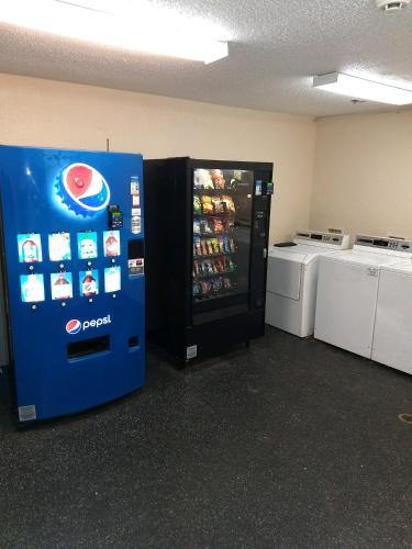 a soda vending machine in a room with two washers at InTown Suites Extended Stay Jacksonville FL - Beach Blvd in Jacksonville