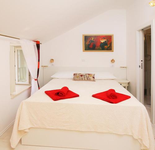 ドゥブロヴニクにあるAngelus Roomsの白いベッドルーム(赤いタオルをベッドに掛けたベッド付)
