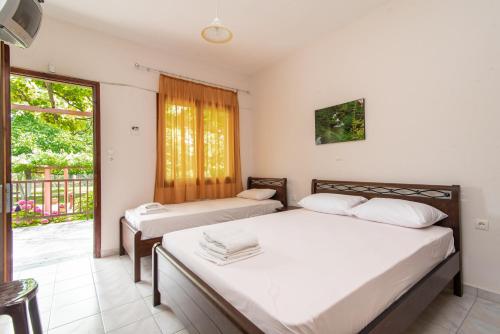 two beds in a room with a balcony at Litochoro Rooms in Plaka Litochorou