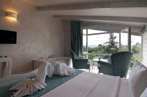 a hotel room with a bed and a tub and a window at Agva Nehir Evi - Adult Only in Agva