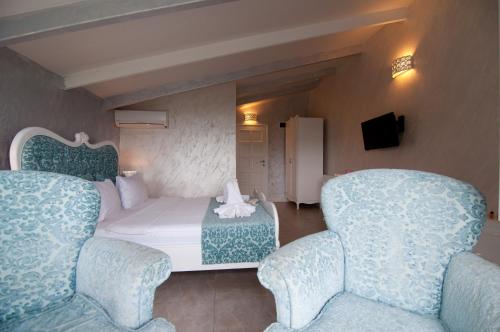 a hotel room with a bed and two chairs at Agva Nehir Evi - Adult Only in Agva