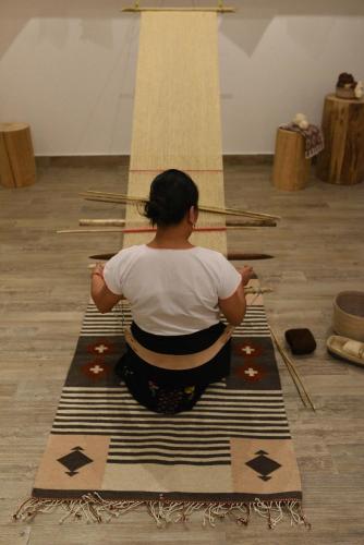 a woman is sitting on a rug in meditation at Unico Hotel Riviera Maya Adults Only in Akumal
