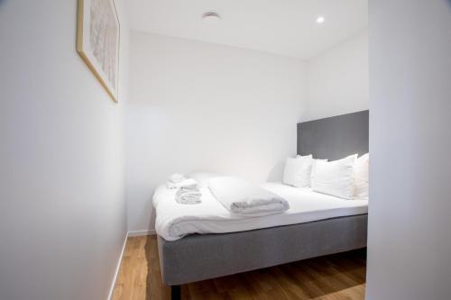 a bedroom with a bed with white sheets and white pillows at ApartDirect Sundbyberg in Sundbyberg