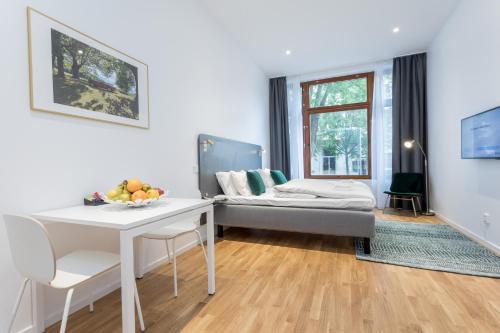 Sala de estar con cama y mesa en ApartDirect Sundbyberg, en Sundbyberg