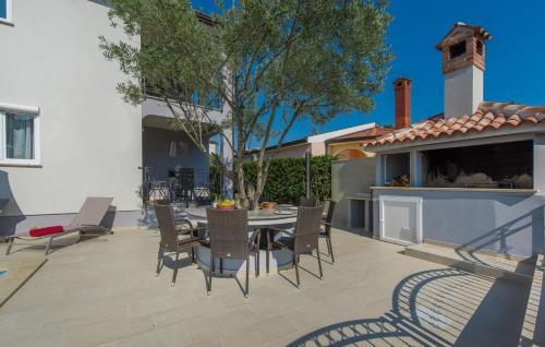 a patio with a table and chairs and a tree at Silver Holiday House in Poreč