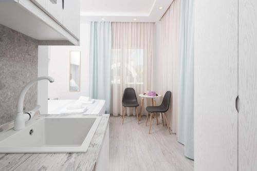 a bathroom with a tub and two chairs and a table at Polyxeni's Studios in Limenas