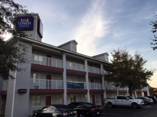 a hotel with cars parked in a parking lot at InTown Suites Extended Stay Jacksonville FL - Orange Park in Orange Park