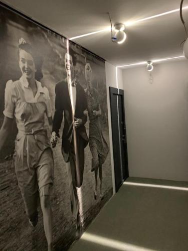 a painting of two women walking on a wall at H49 Apartman Wellness & Spa - Adults only in Sovata