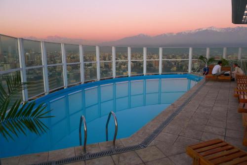 a swimming pool on the roof of a building with a view at Chilean Suites Providencia in Santiago