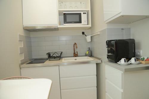 a small kitchen with a sink and a microwave at H49 Apartman Wellness & Spa - Adults only in Sovata