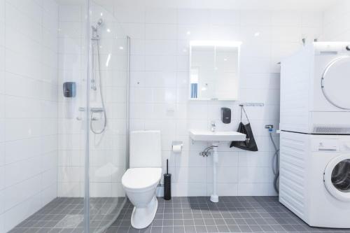 a bathroom with a toilet and a shower and a sink at ApartDirect Sundbyberg in Sundbyberg