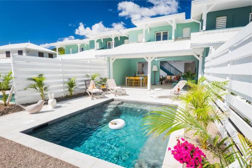 a swimming pool in the backyard of a house at Villa Banc de sable, accès direct à la plage in Le Diamant