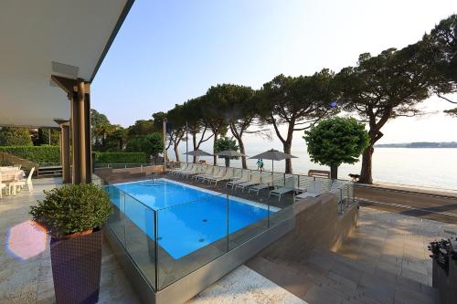 a swimming pool with a view of the water at Hotel San Marco in Peschiera del Garda