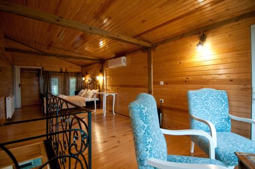 a living room with wooden walls and blue and white chairs at Agva Nehir Evi - Adult Only in Agva