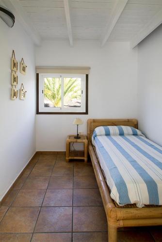 a bedroom with a bed and a window at Finca Arbequina in Pájara