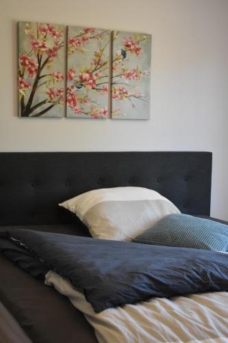 um quarto com uma cama com duas pinturas na parede em TOP Ferien Apartment Bohmte em Bohmte