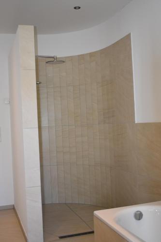 a shower with a glass door in a bathroom at TOP Ferien Apartment Bohmte in Bohmte