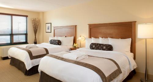 a hotel room with two beds and a window at Temple Gardens Hotel & Spa in Moose Jaw